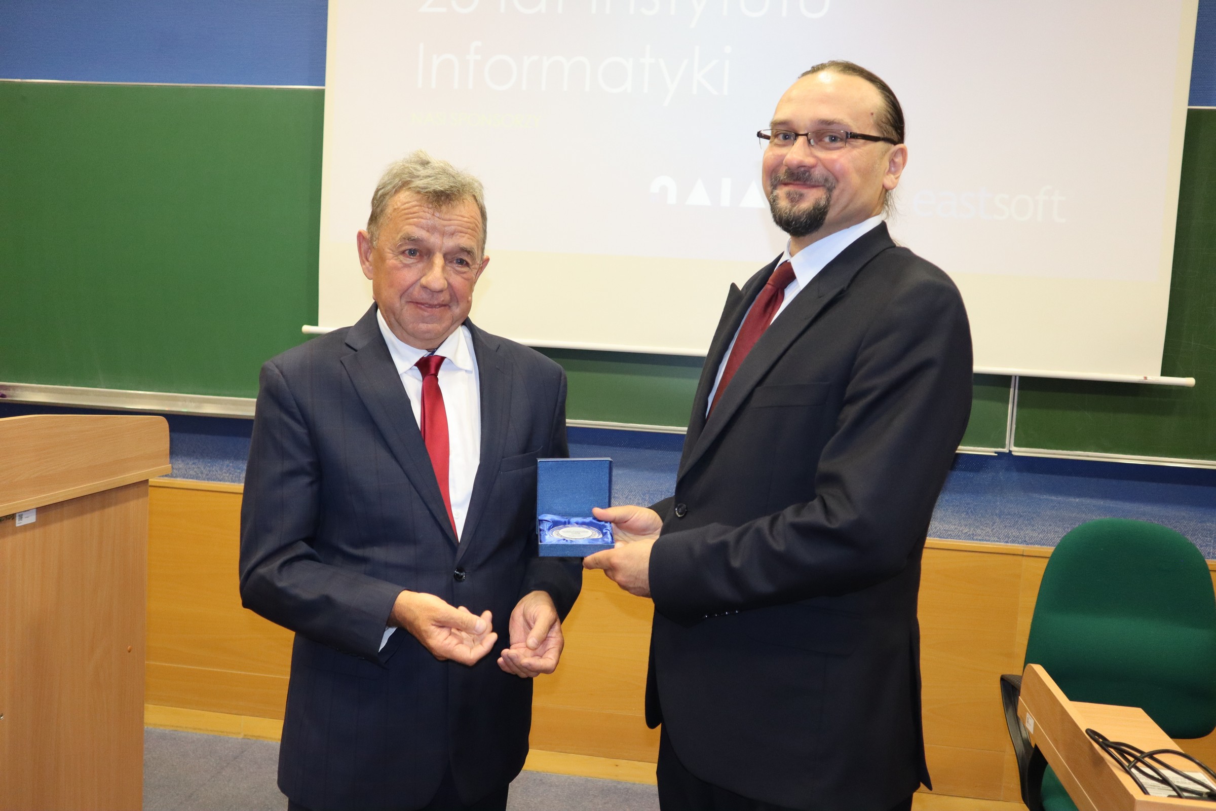 Dziekan WNSP Cezary Sempruch wręcza pamiątkowy medal dyrektorowi Arturowi Niewiadomskiemu